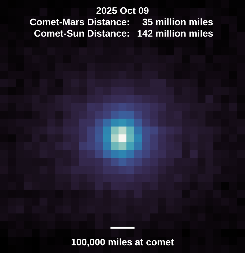 A square, pixelated image with a dark background. At the center is a roughly circular cluster of bright pixels, transitioning from white at the very center to light blue, then darker blue and purple as it spreads outward. The edges and corners of the image are mostly dark purple and black pixels.